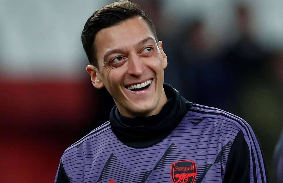 Arsenal playmaker Mesut Ozil laughing