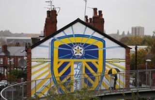A mural of the Leeds United crest on the side of a house