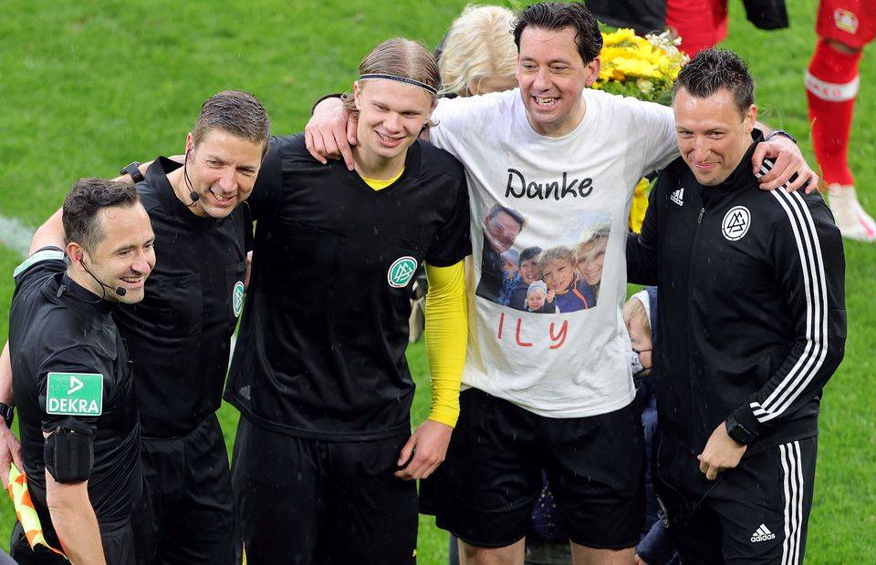 Erling Haaland poses for pictures with the officials after Dortmund vs Leverkusen