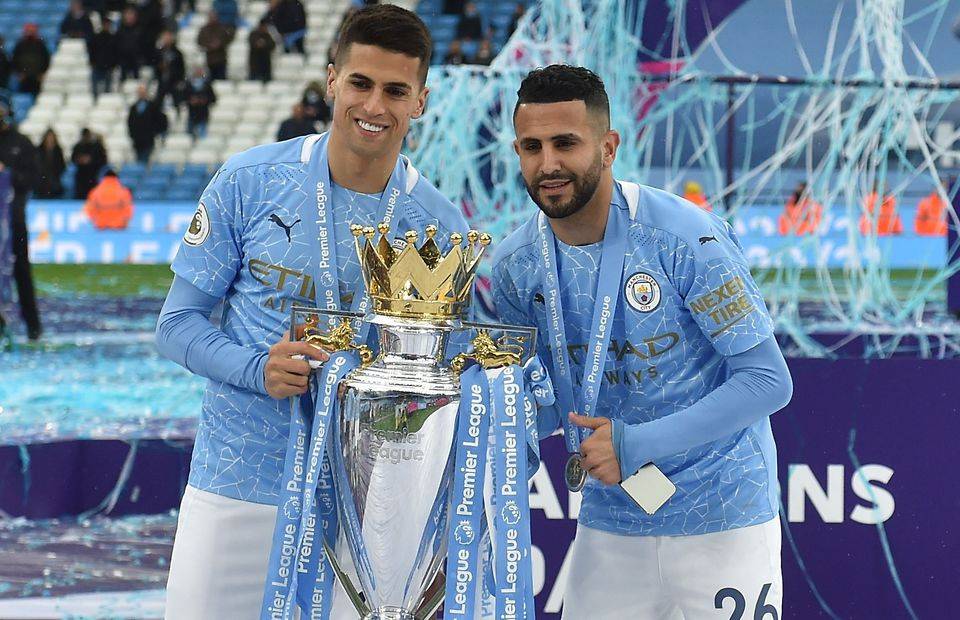 Man City's Riyad Mahrez and Joao Cancelo celebrate winning the Premier League