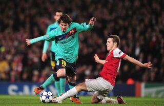 Jack Wilshere of Arsenal tackles Barcelona star Lionel Messi in the Champions League in 2011