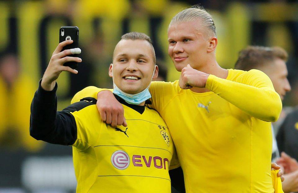 Borussia Dortmund's Erling Braut Haaland takes a selfie with a fan after the match