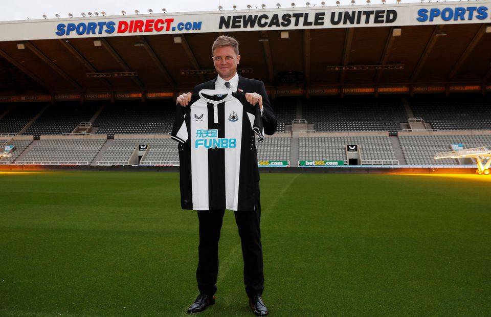 Newcastle manager Eddie Howe holding up a club shirt