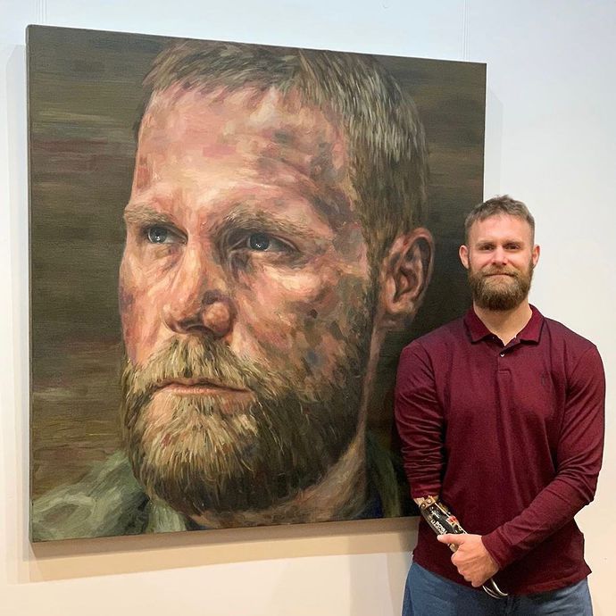 Mark Ormrod proudly poses in front of his portrait