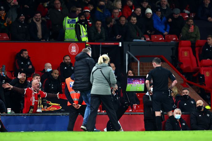Michael Oliver consults his pitchside monitor during Man Utd v Aston Villa