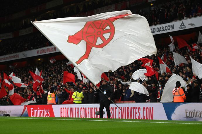 Arsenal fan waves a flag before their Carabao Cup semi-final against Liverpool.