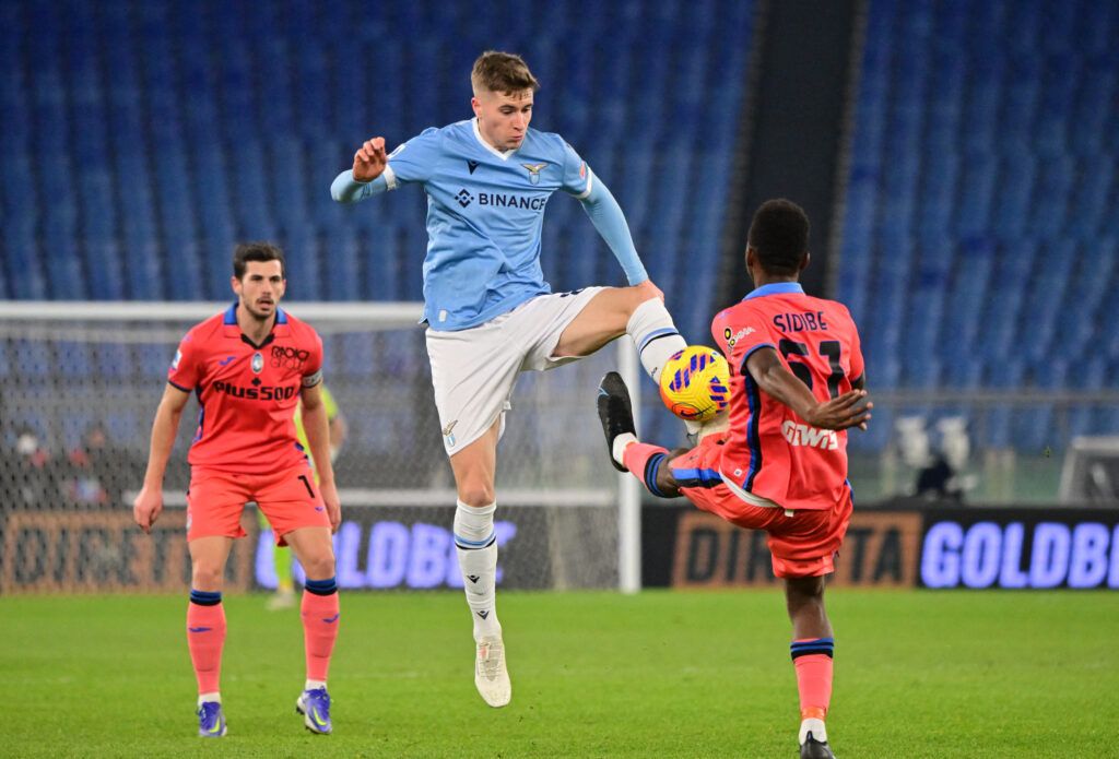 Lazio's Toma Basic in action with Atalanta's Alasanne Sidibe during the Serie A