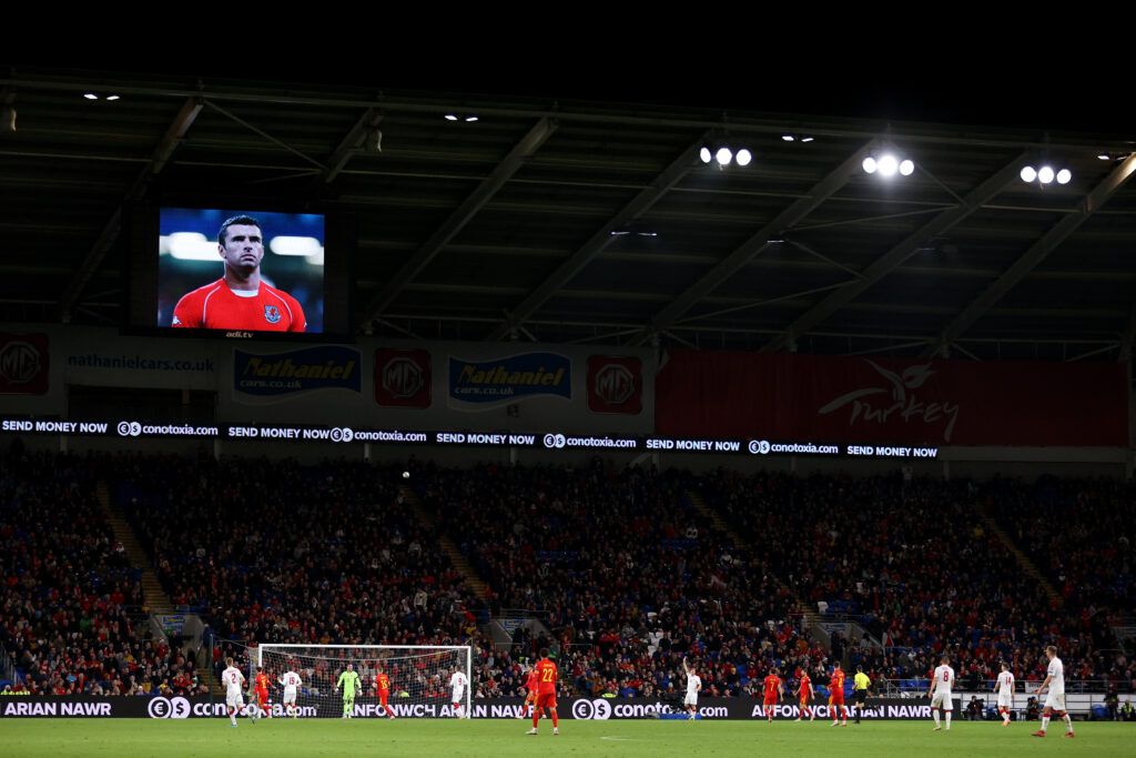 Fans applaud as the LED screen displays of Gary Speed during the World Cup Qualifier 