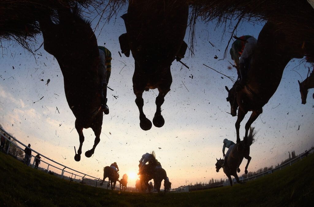 Runners and riders jump the third last during the Fulke Walwyn Kim Muir Challenge Cup Handicap Chase