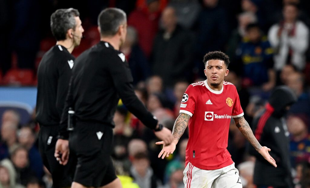 Jadon Sancho of Manchester United complains to the Referee Slavko Vincic after their sides defeat during the UEFA Champions League Round Of Sixteen Leg Two match between Manchester United and Atletico Madrid