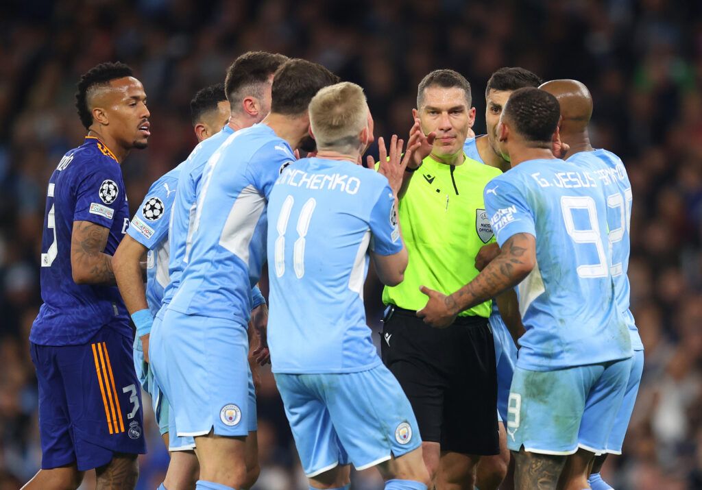 Manchester City players surround referee Istvan Kovacs during the UEFA Champions League Semi Final Leg One match between Manchester City and Real Madrid at City of Manchester Stadium on April 26, 2022 in Manchester, England. 