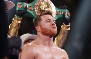 Canelo Alvarez in the boxing ring with his title being held up behind him