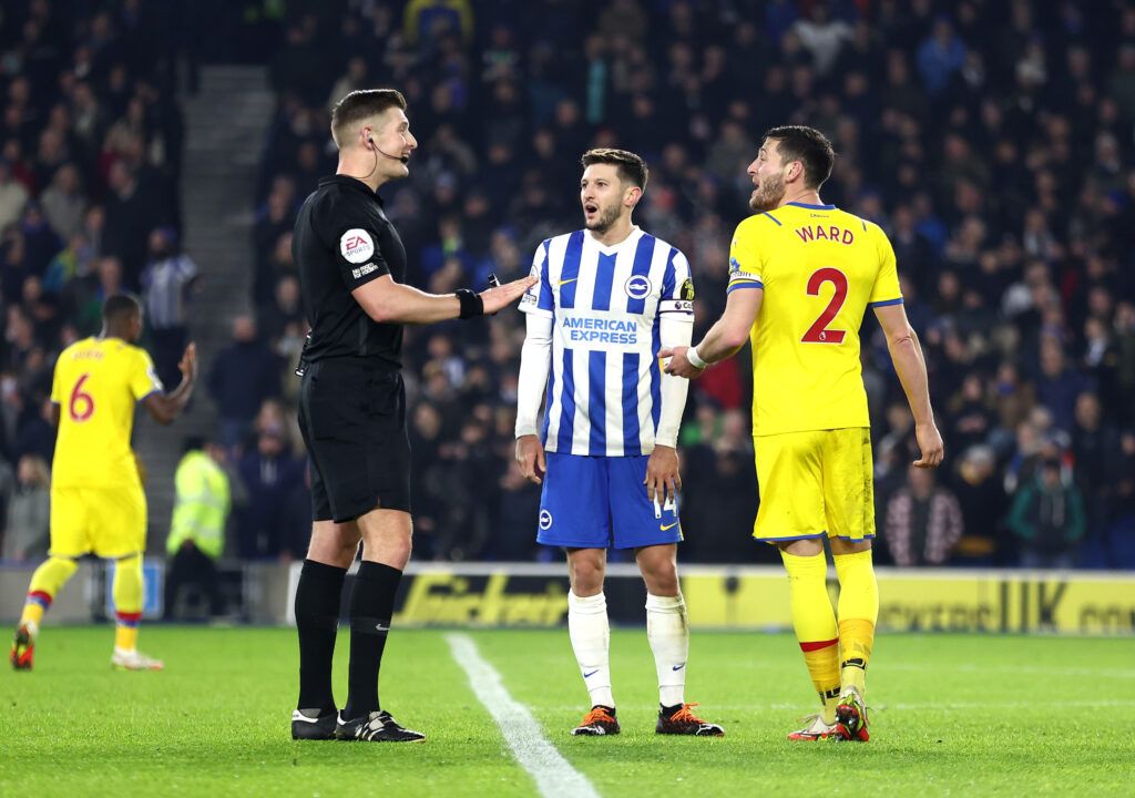 Adam Lallana of Brighton & Hove Albion and Joel Ward of Crystal Palace speak to referee Robin Jones after a VAR incident during the Premier League match between Brighton & Hove Albion  and  Crystal Palace at American Express Community Stadium on January 14, 2022 in Brighton, England.