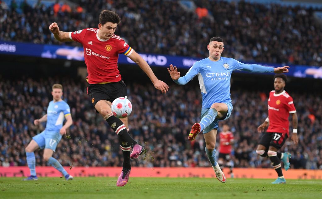 Phil Foden of Manchester City is challenged by Harry Maguire of Manchester United during the Premier League match between Manchester City and Manchester United at Etihad Stadium on March 06, 2022 in Manchester, England.
