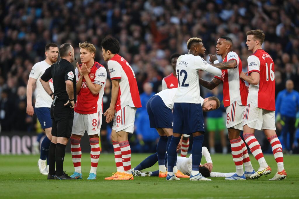 Gabriel Magalhaes of Arsenal clashes with Emerson Royal of Tottenham Hotspur before Match Referee, Paul Tierney shows a red card to Rob Holding of Arsenal following a foul on Heung-Min Son of Tottenham Hotspur during the Premier League match between Tottenham Hotspur and Arsenal at Tottenham Hotspur Stadium on May 12, 2022 in London, England.