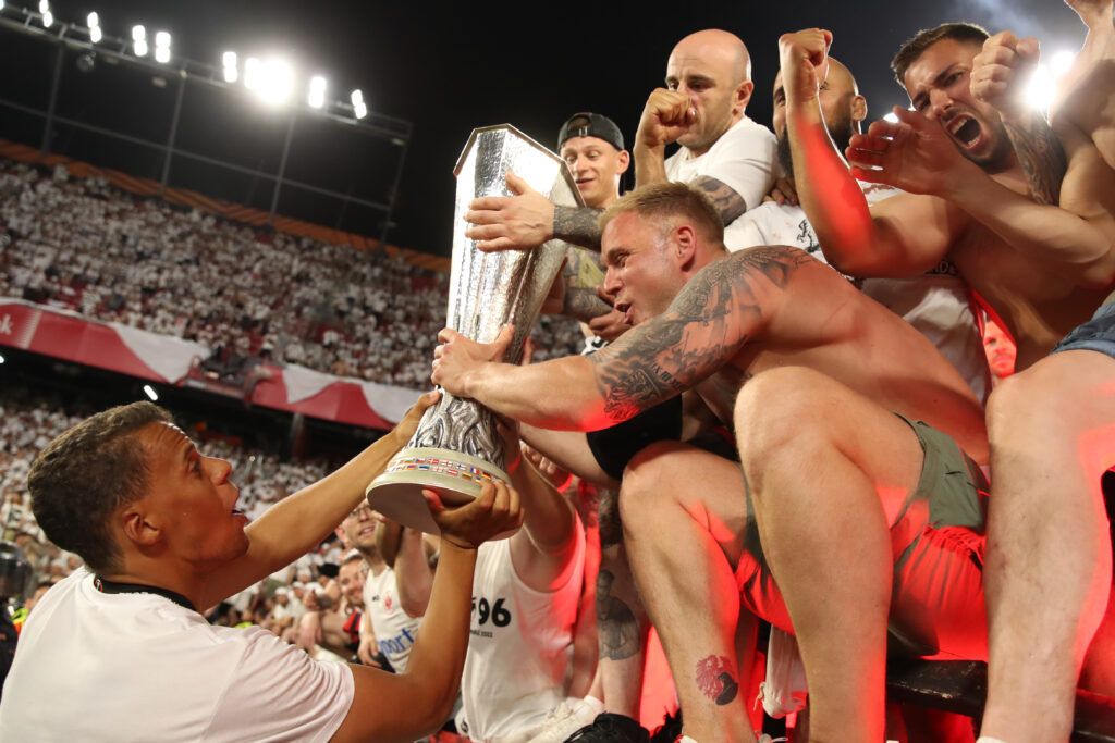 Timothy Chandler of Eintracht Frankfurt and Eintracht Frankfurt fans celebrate with the UEFA Europa League Trophy following their sides victory in the UEFA Europa League final match between Eintracht Frankfurt and Rangers FC at Estadio Ramon Sanchez Pizjuan on May 18, 2022 in Seville, Spain.