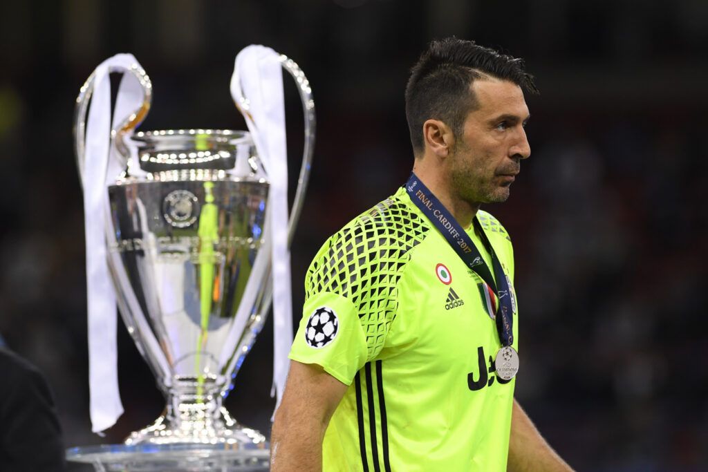 Gianluigi Buffon walks past Champions League trophy
