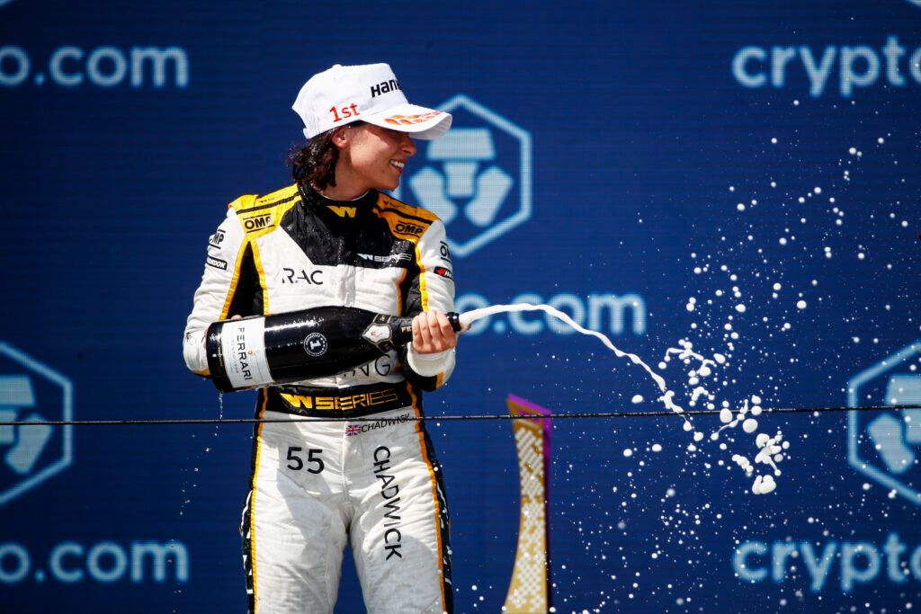 Jamie Chadwick sprays champagne on the W Series podium