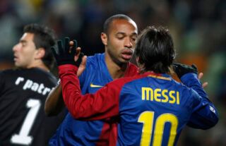 Henry and Messi celebrate.