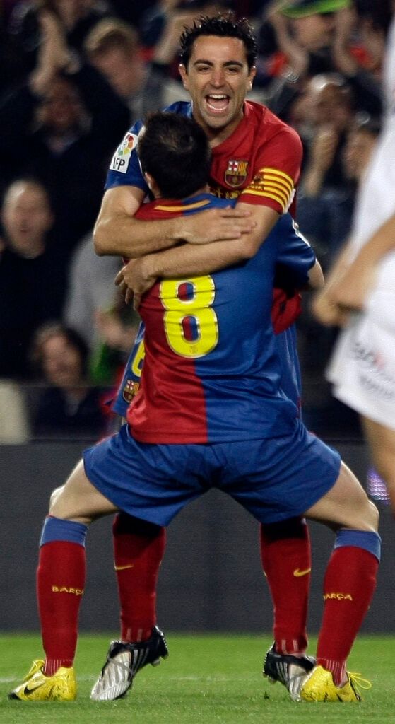 Xavi and Iniesta celebrate.