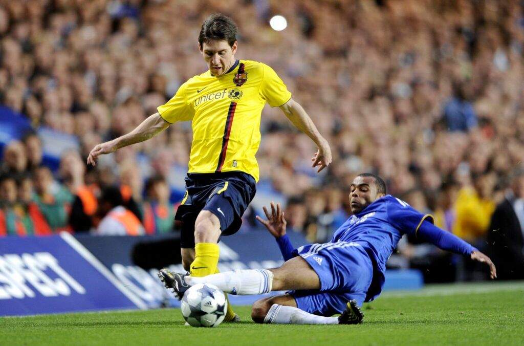 Cole tackles Messi for Chelsea.