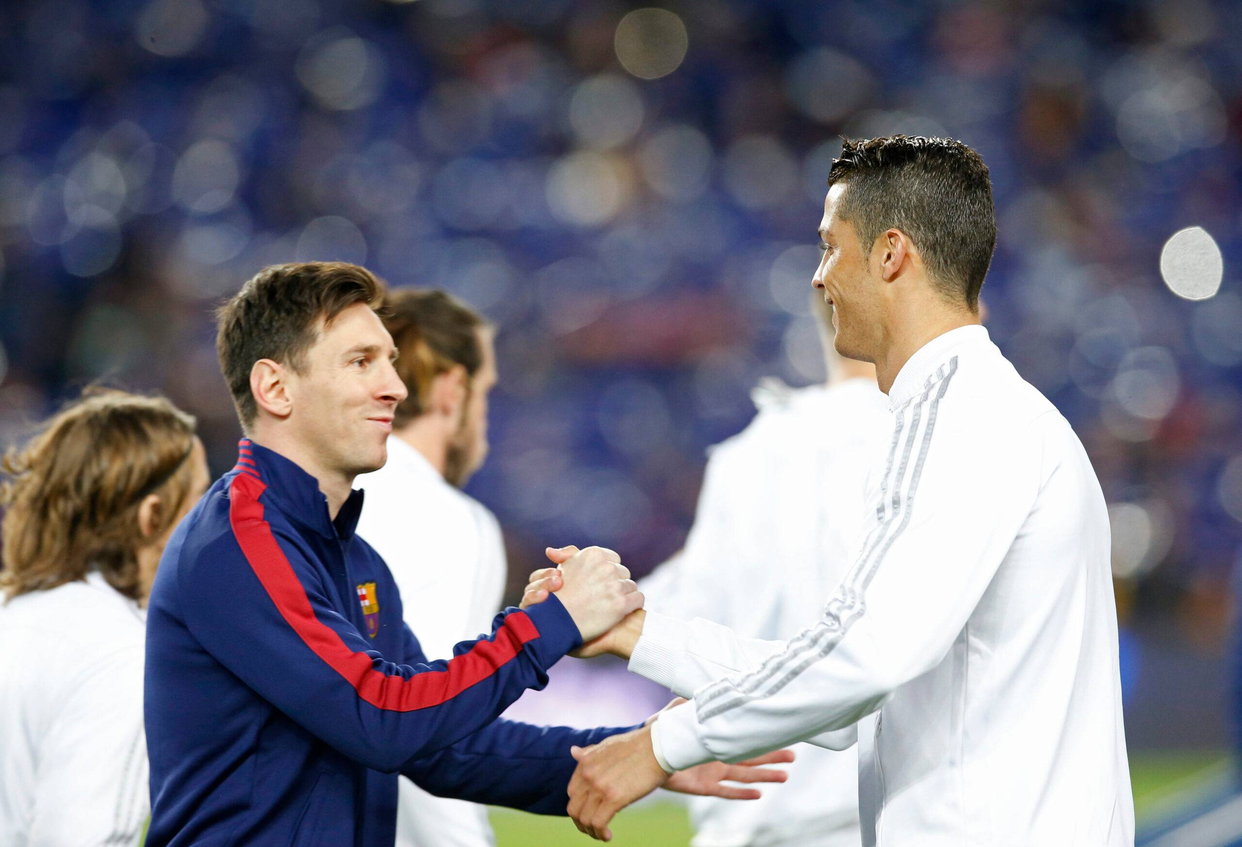 Messi and Ronaldo shake hands.