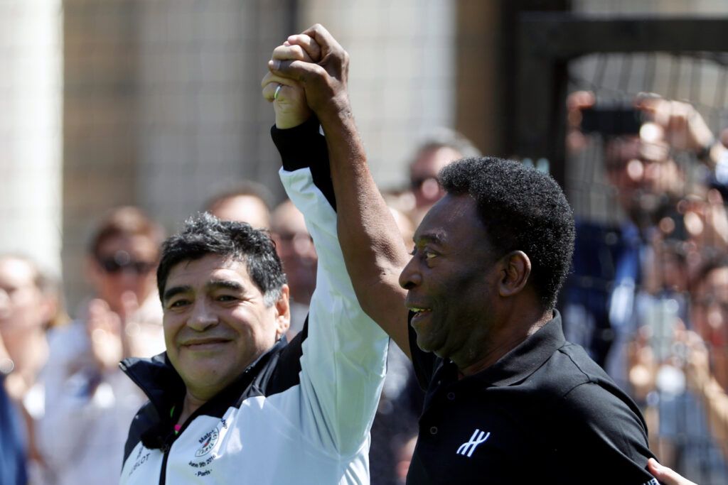 Maradona and Pele hold hands.