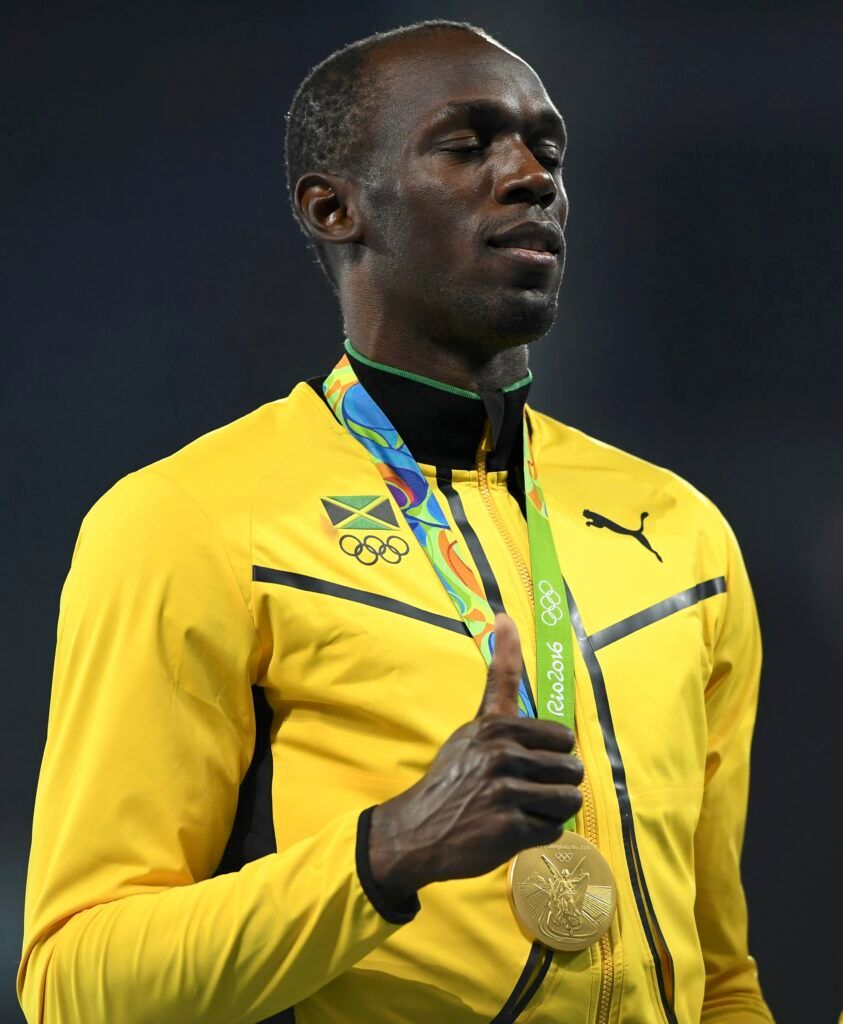 Bolt holding Olympic gold.