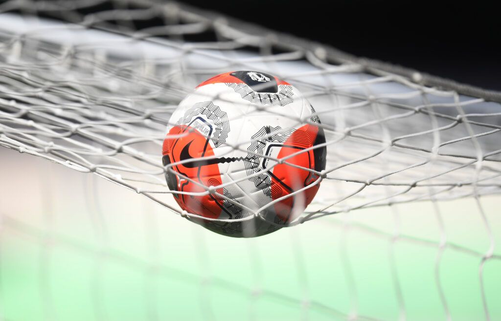 Football sits on the goal net.