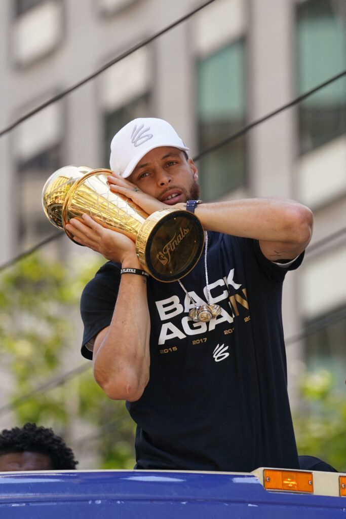Curry holds the MVP trophy.