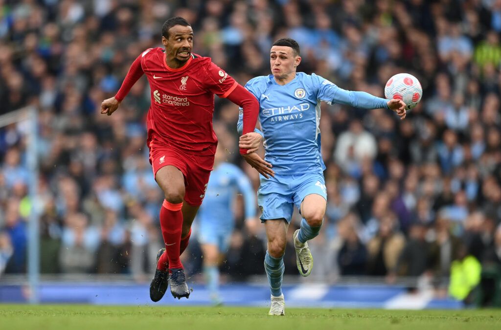 Joel Matip of Liverpool battles for possession with Phil Foden