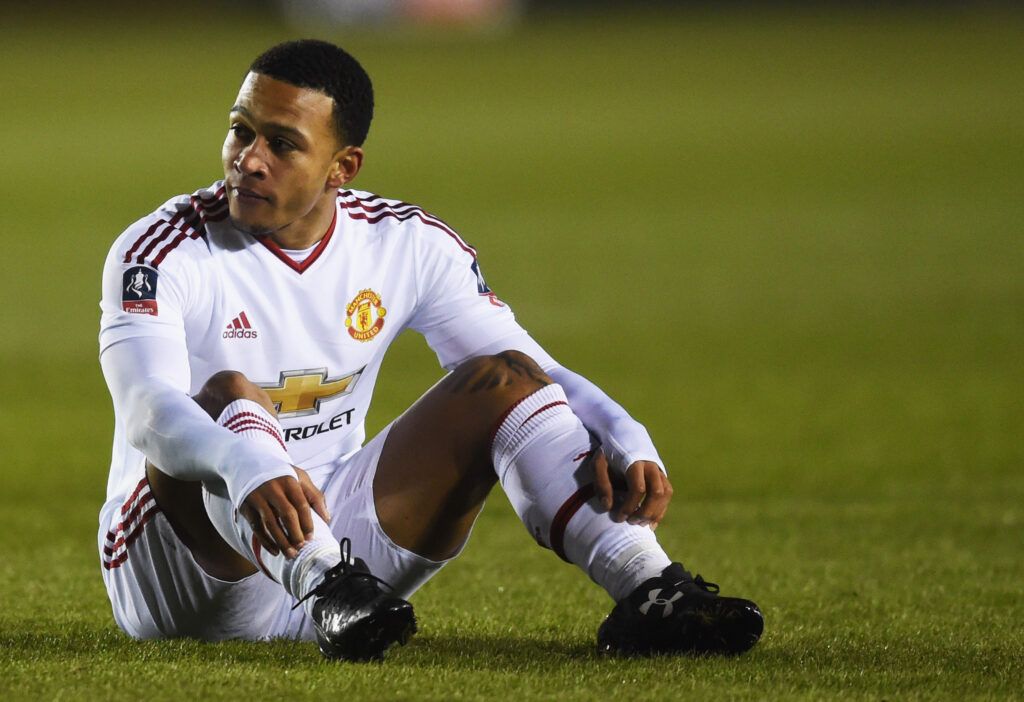 Depay sits on the pitch in an FA Cup tie