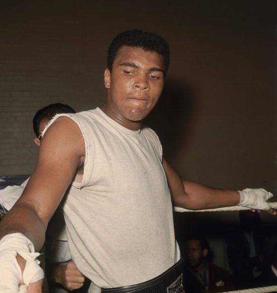 Ali standing in a boxing ring.