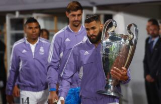 Benzema carrying the Champions League trophy.