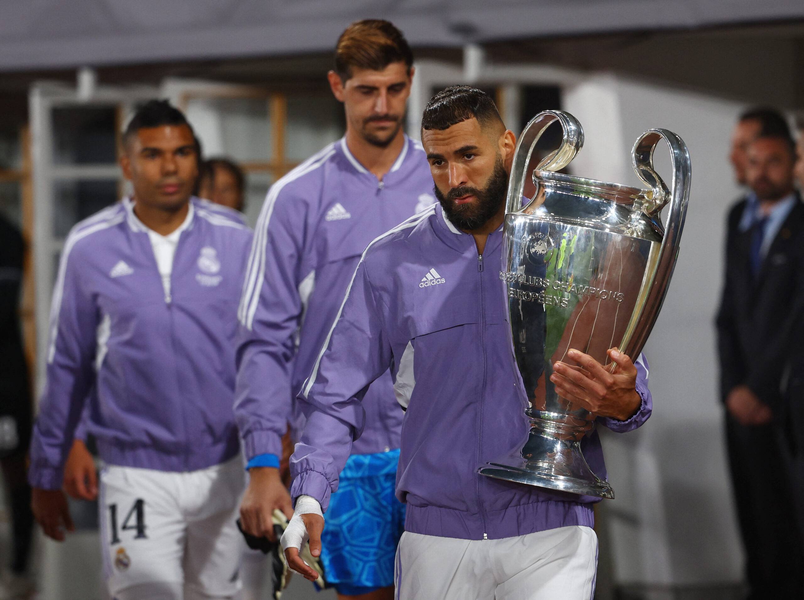 Benzema carrying the Champions League trophy.