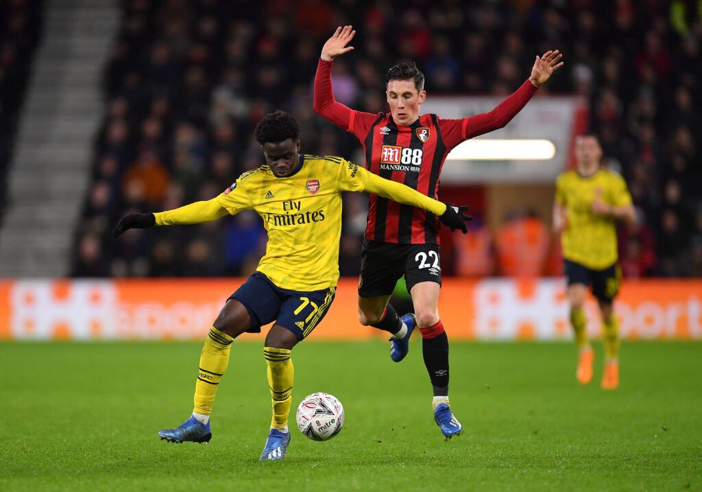 Bukayo Saka of Arsenal battles for possession with Harry Wilson