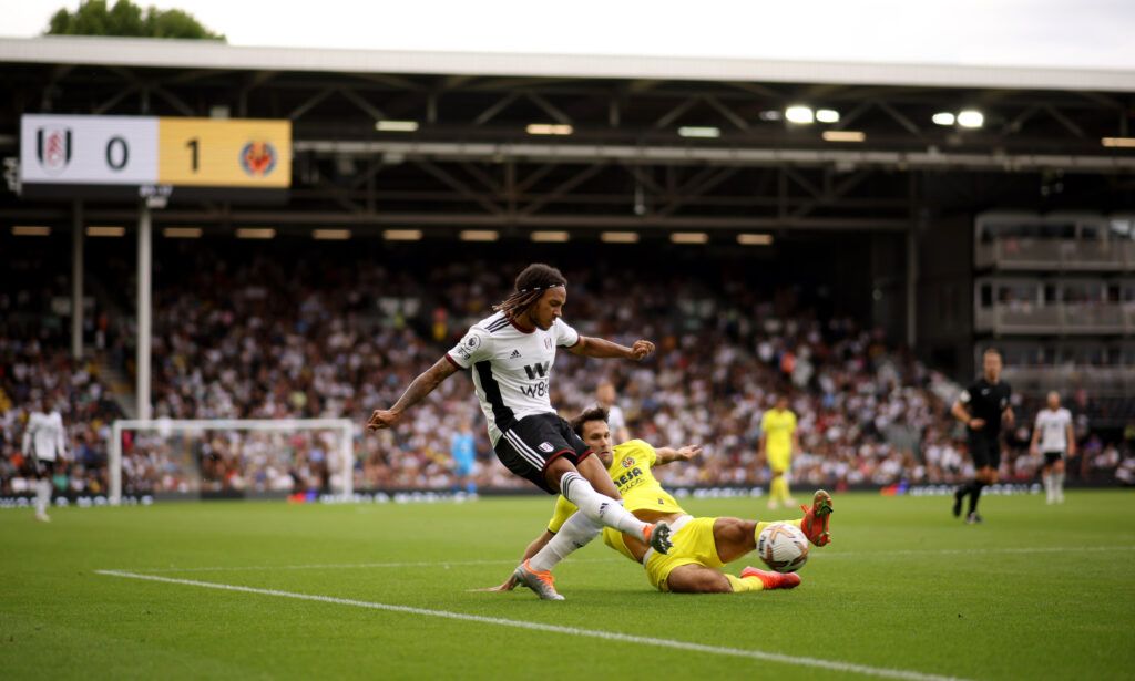 Kevin Mbabu of Fulham crosses the ball under pressure from Jorge Cuenca