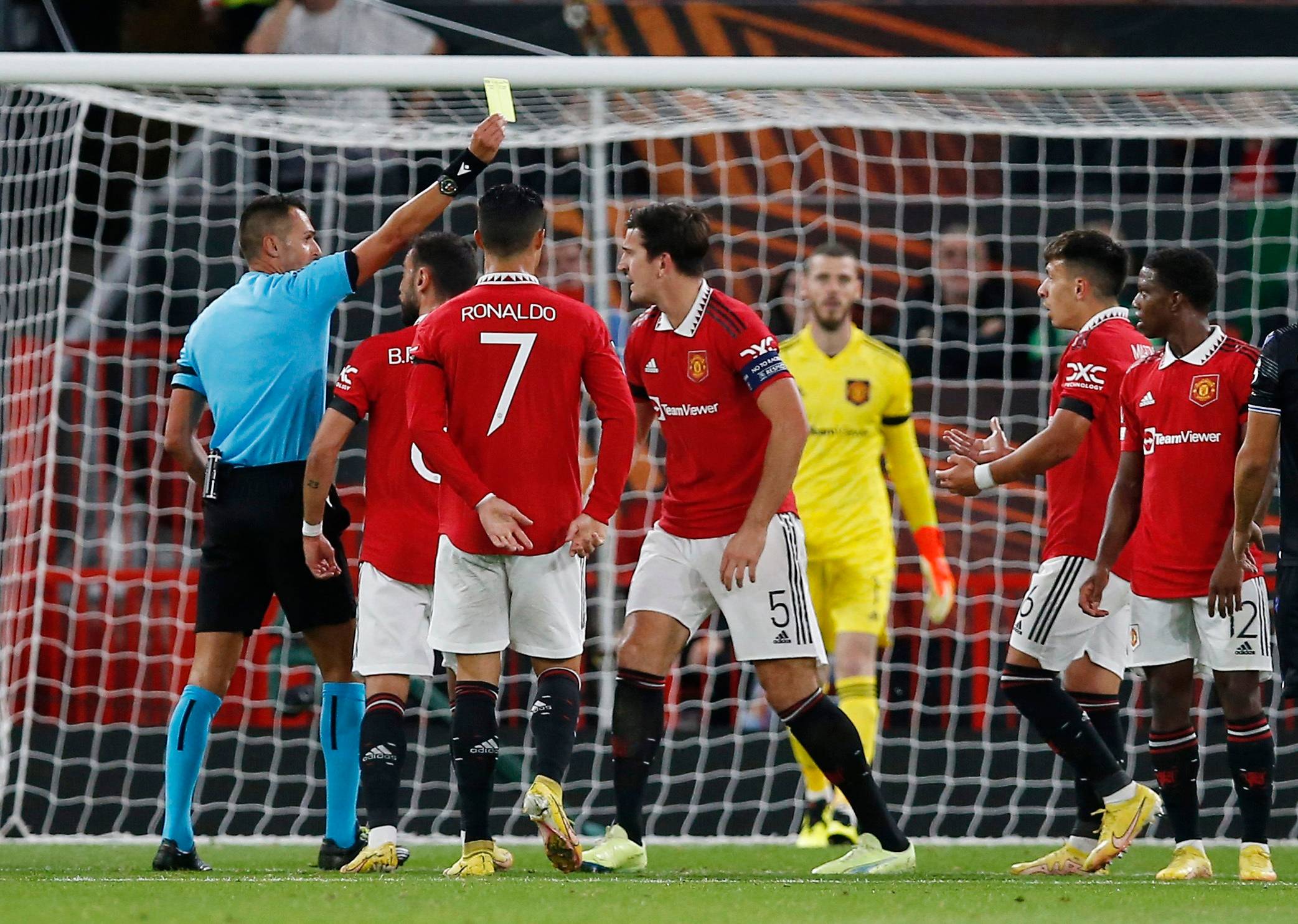 Manchester United players protest after a penalty is given against Lisandro Martinez