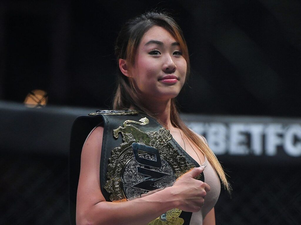Angela Lee standing with ONE FC title in the cage