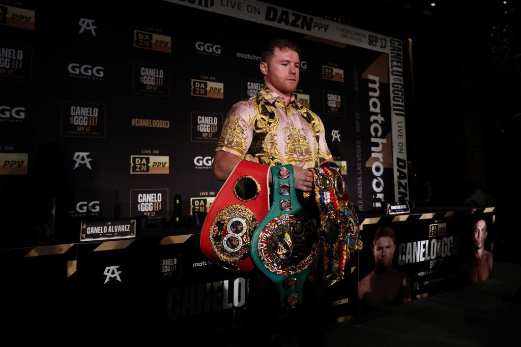 Canelo Alvarez posing with Boxing belts