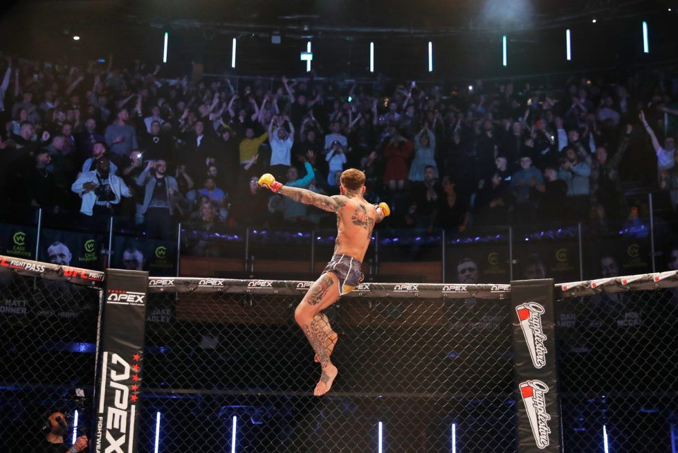 Jordan Vucenic celebrating in the Cage Warriors cage