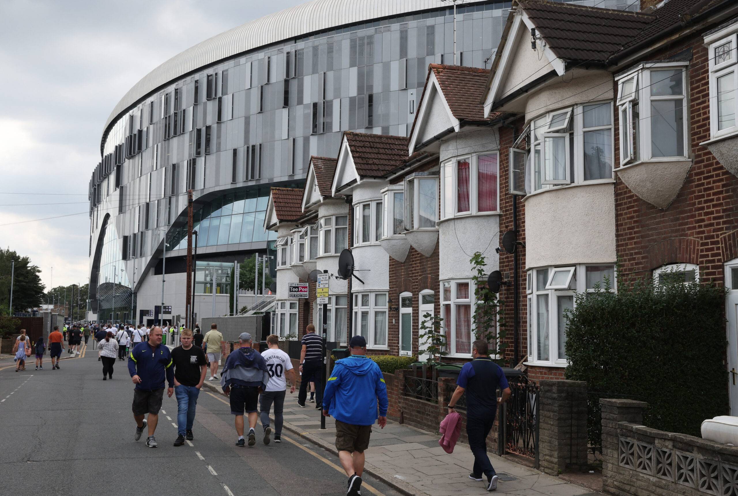 Fans walk to Tottenham Hotspur Stadium.