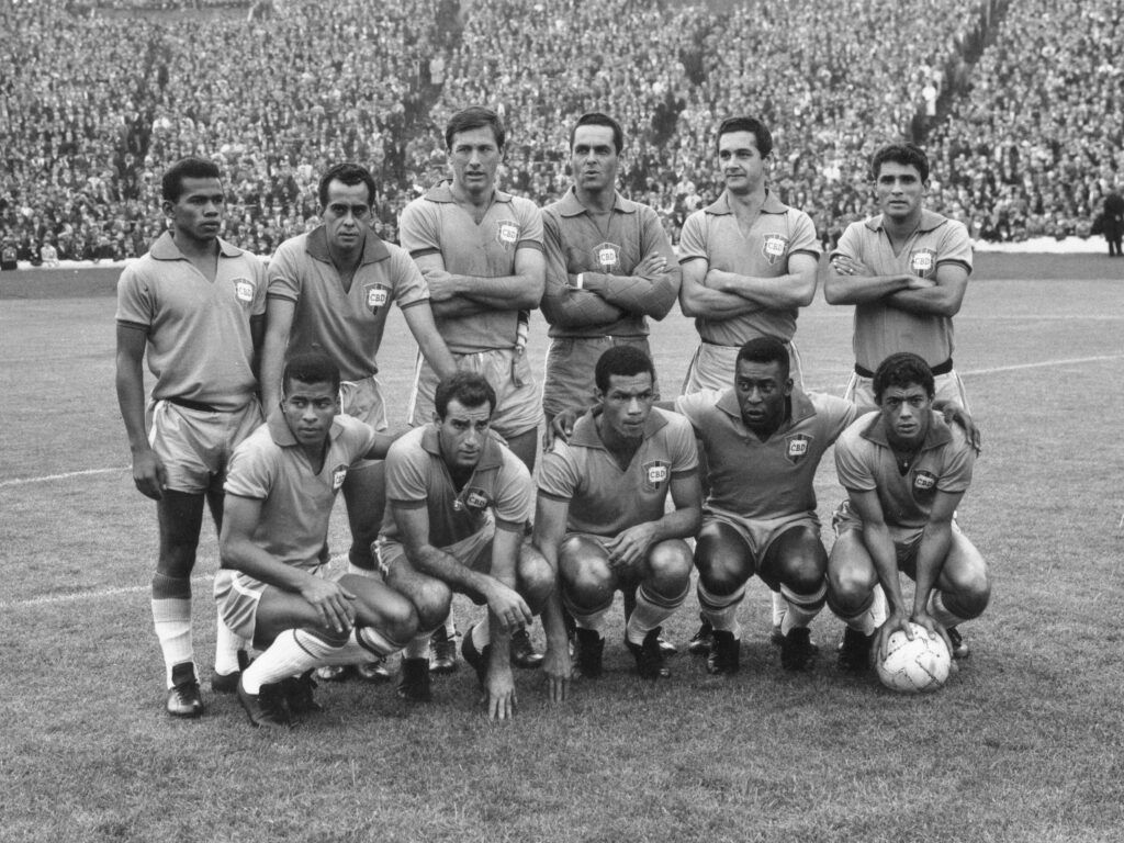 A seleção brasileira de futebol na Grã-Bretanha para a Copa do Mundo de 1966. Eles são vistos fazendo fila antes do amistoso contra a Escócia no Hampden Park.  Pelé, o jogador de futebol mais famoso entre as gerações, linhas 1 e 2 da direita