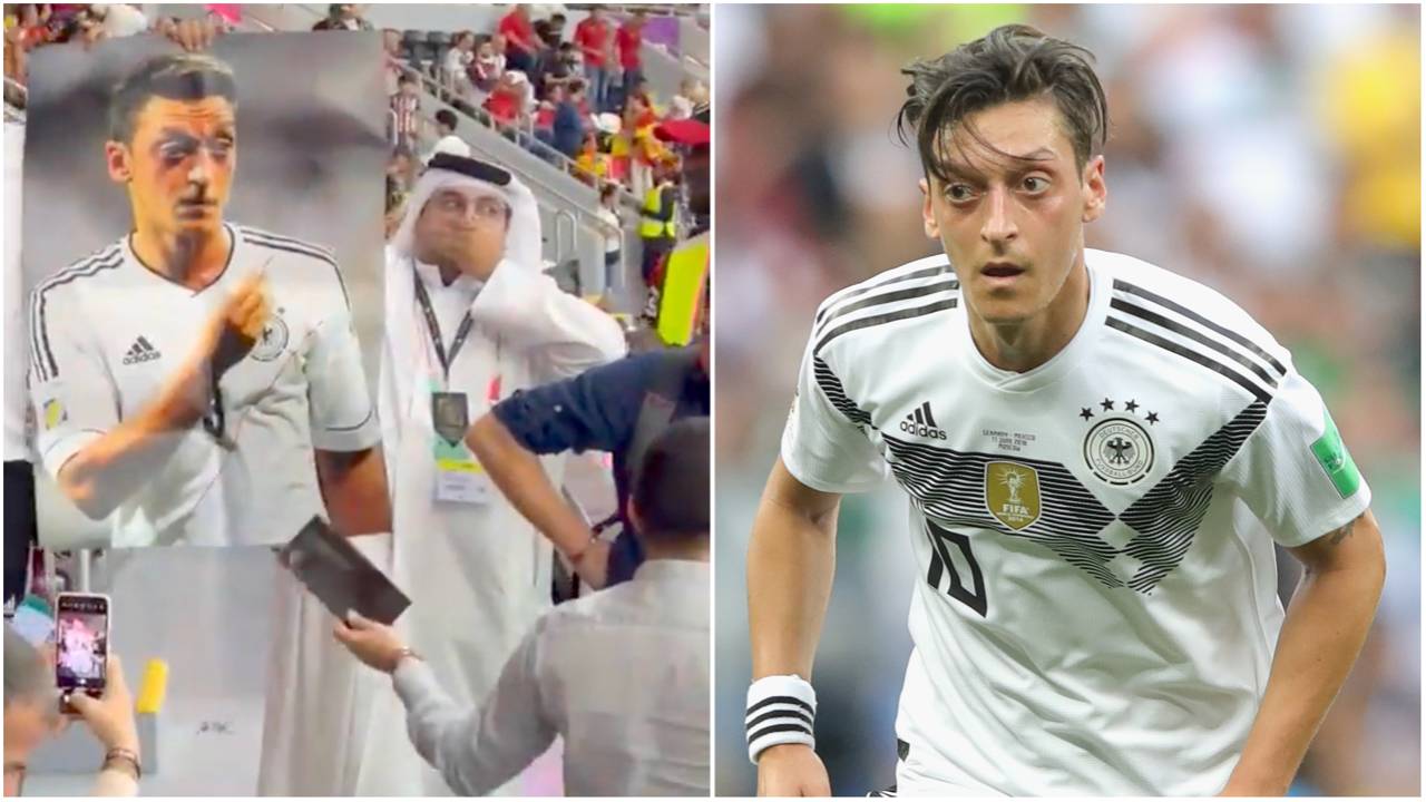 Fans hold pictures of Mesut Ozil while covering mouths during Germany’s 1-1 draw vs Spain