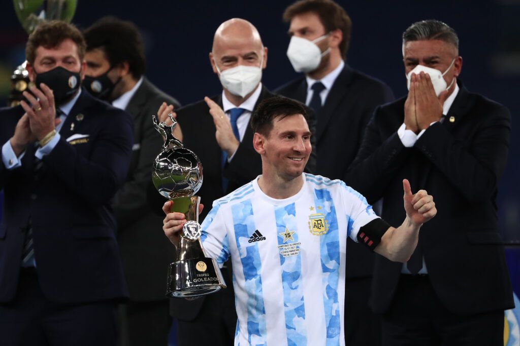 Lionel Messi of Argentina celebrates after receiving the top scorer award as (back L-R) President of CONMEBOL Alejandro Dominguez, President of FIFA Gianni Infantino and President of AFA Claudio Tapia applaud during the final of Copa America Brazil 2021 between Brazil and Argentina at Maracana Stadium on July 10, 2021 in Rio de Janeiro, Brazil