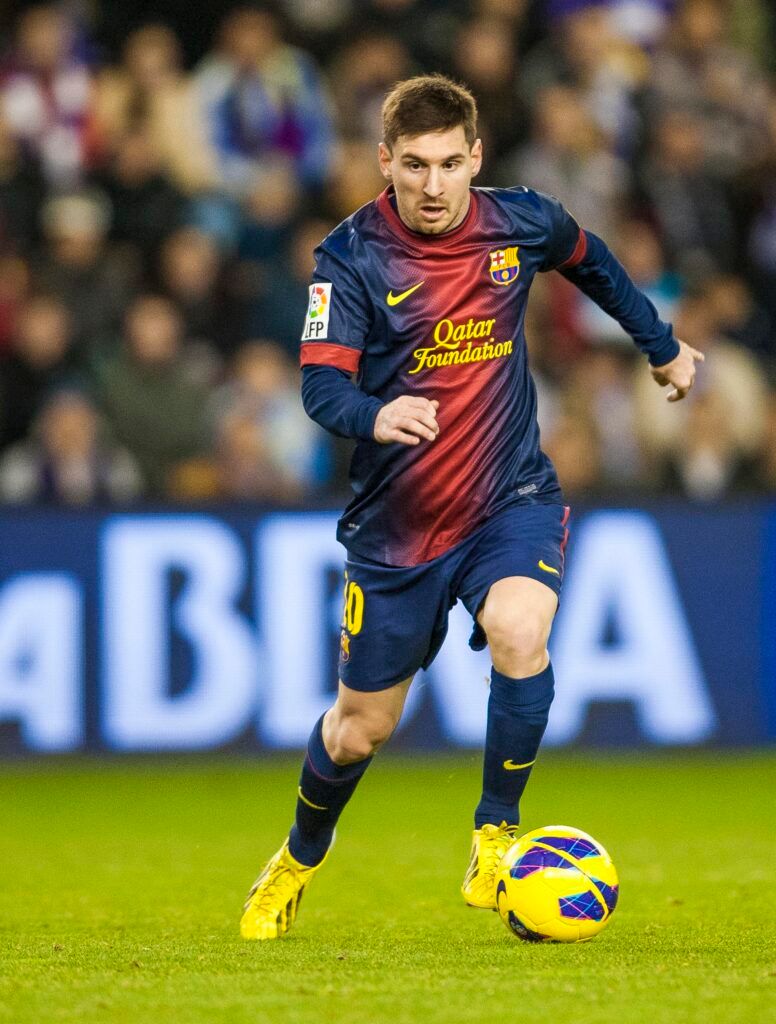 Messi dribbling with the ball for Barcelona.