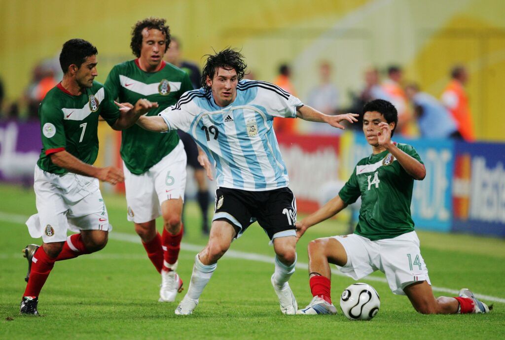 Lionel Messi fights for the ball vs Mexico at the 2010 World Cup