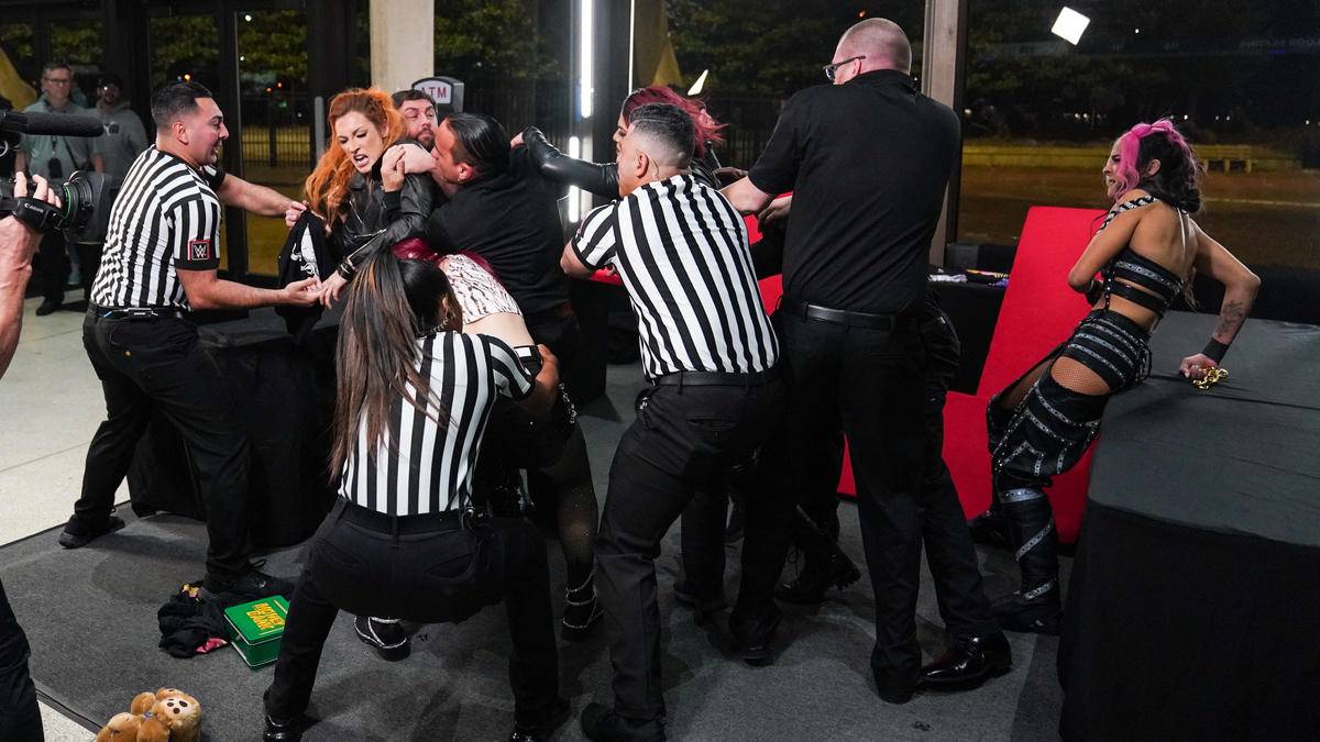 Becky Lynch and Damaga CTRL are held by security during a brawl