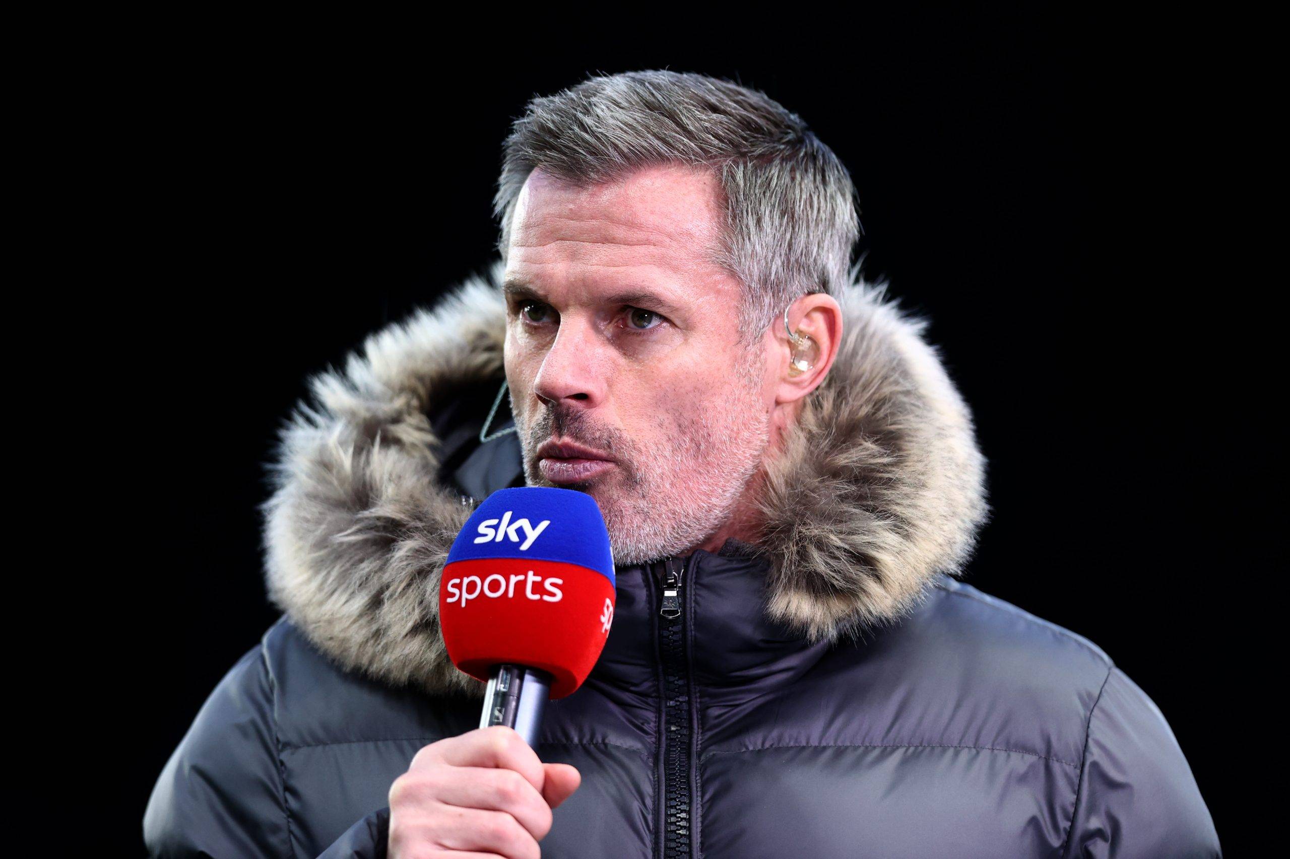 Carragher holding a Sky Sports microphone.